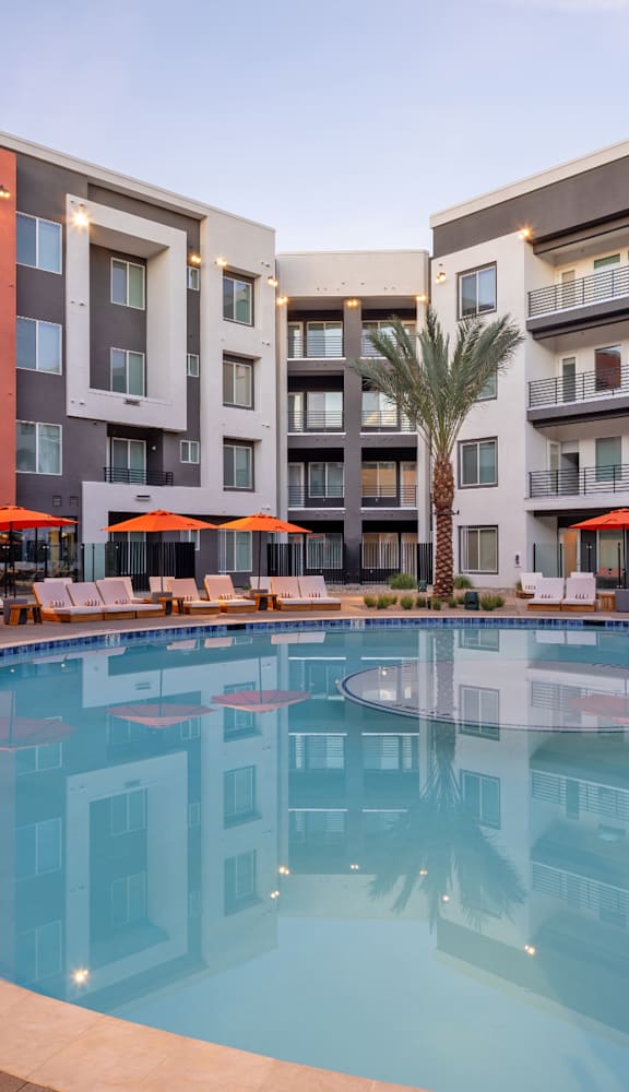 A large swimming pool in front of apartment buildings.
