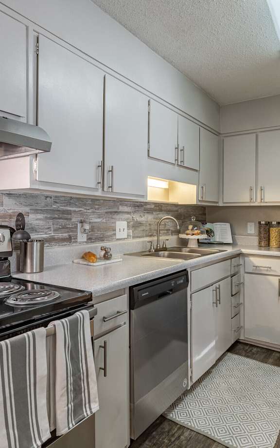 a kitchen with white cabinets and stainless steel appliances at Tucker Square, Georgia