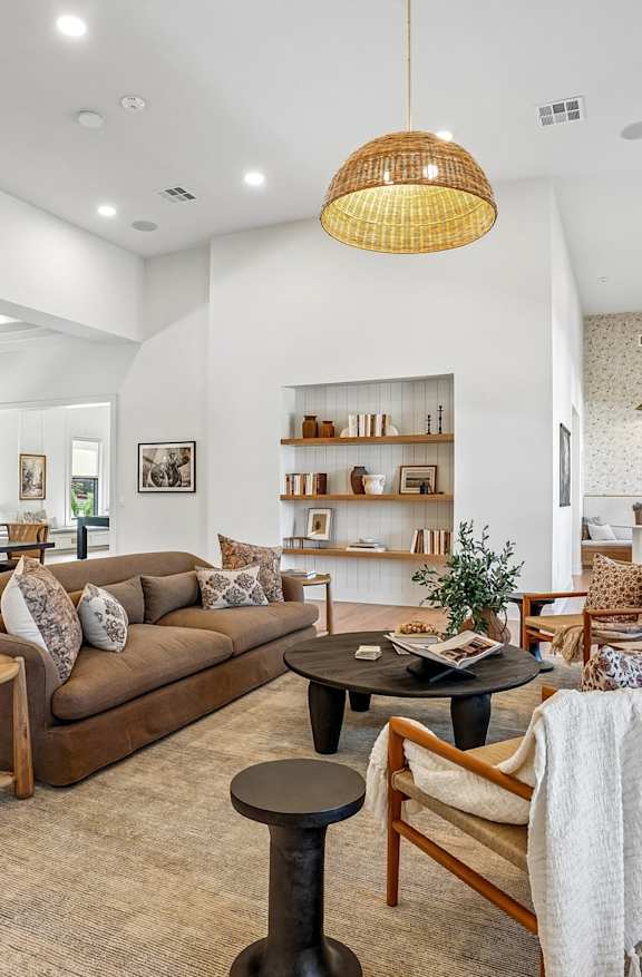 A modern living room with a large couch, a coffee table, and a fireplace.
