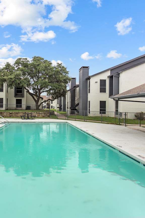 A swimming pool in front of apartment buildings.