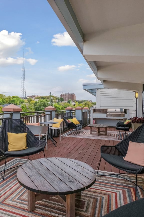 a furnished balcony with a table and chairs and a view of the city