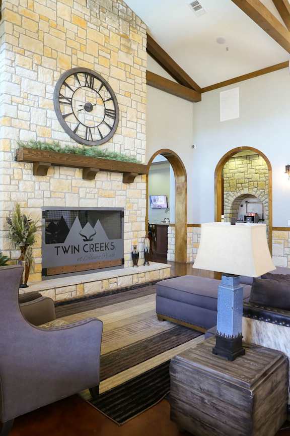 A living room with a stone wall and a large clock.