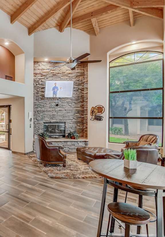 A spacious living room with a fireplace and a dining table set up.