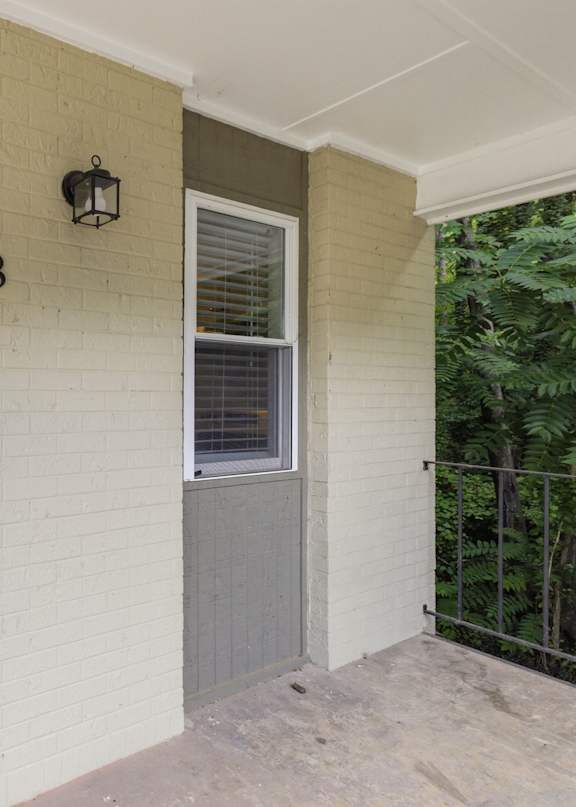 A white door with a black handle is on the left and a black lantern is on the wall above the number 18.
