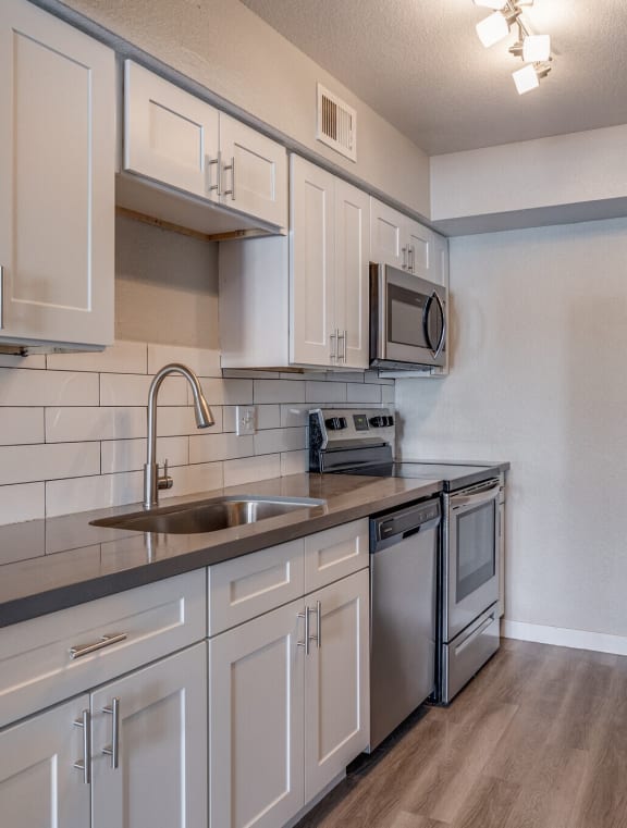 an kitchen with stainless steel appliances and white cabinets at Tides on Southern, Mesa Arizona