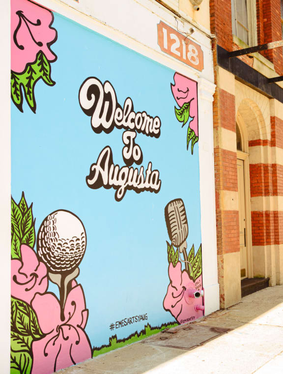 a mural on the side of a building that reads welcome  at Canalside, Augusta, GA