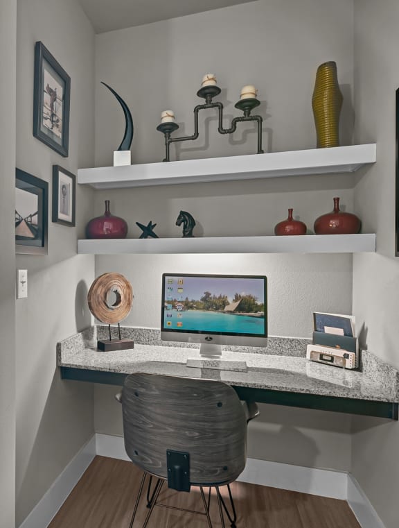 a home office with a computer desk and a window