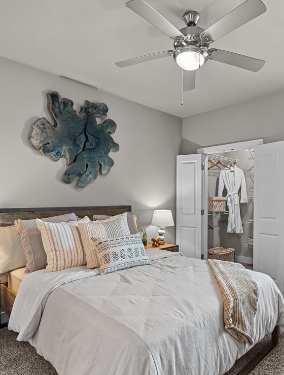 a bedroom with a large bed and a ceiling fan