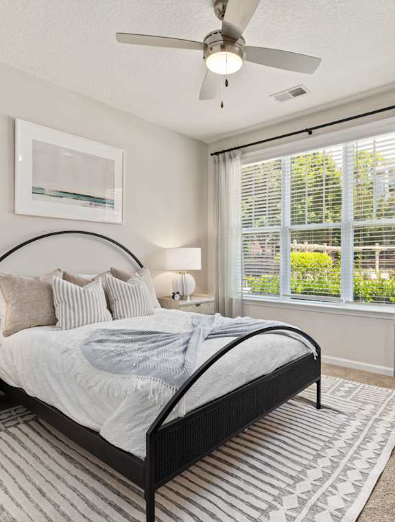 a bedroom with a bed and a ceiling fan