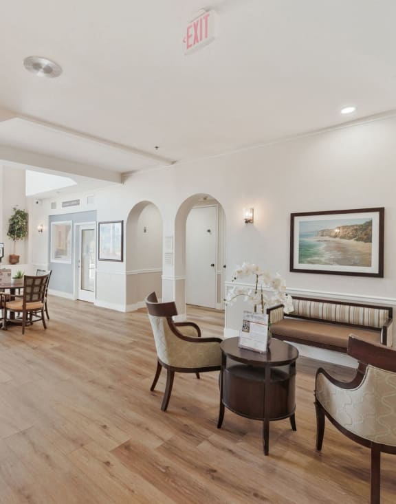 the living room and dining area of a house with wooden floors and furniture