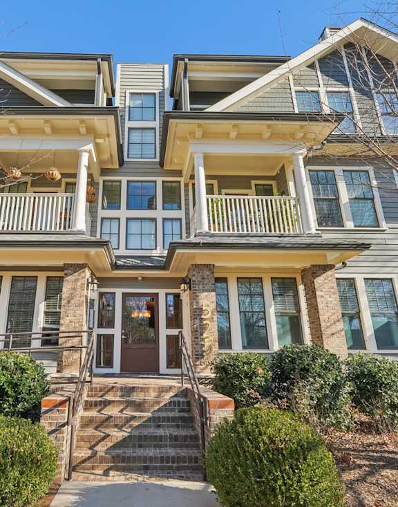 A large, two-story house with a front porch and multiple windows.