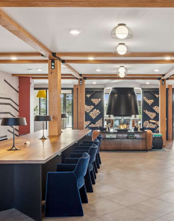 a wall of firewood in a room with a chair