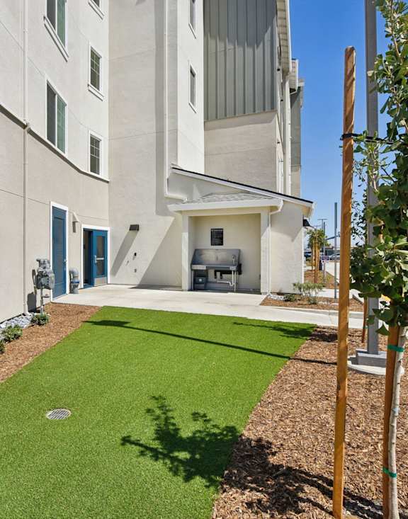 A modern building with a green lawn in front.at Terracina at Winding Creek, Roseville California