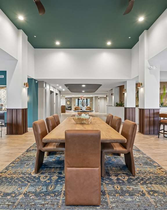 A large room with a long table and chairs in the middle.