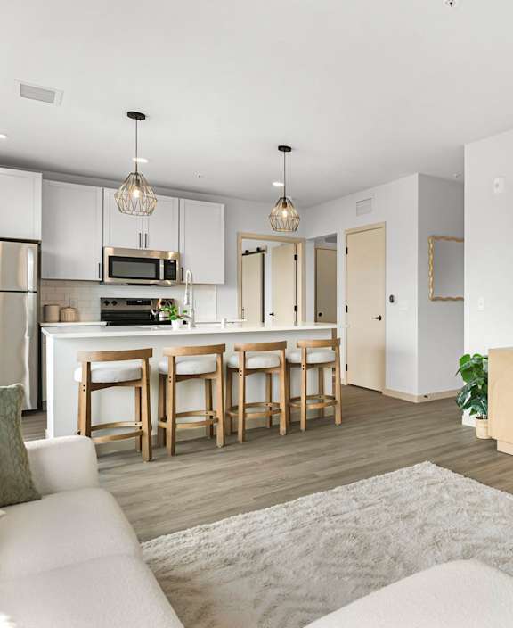 A modern kitchen with a dining area and a living room.