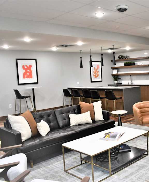 A modern living room with a black couch and a coffee table.