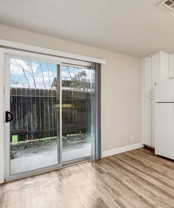 A kitchen with white cabinets and a white fridge.