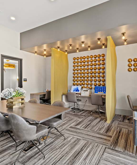 A modern living room with a grey table and blue chairs.