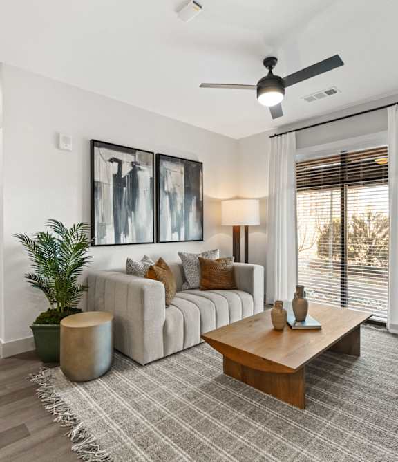 A modern living room with a grey carpet and a wooden coffee table.