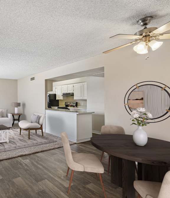 A living room with a couch, chairs, and a dining table.