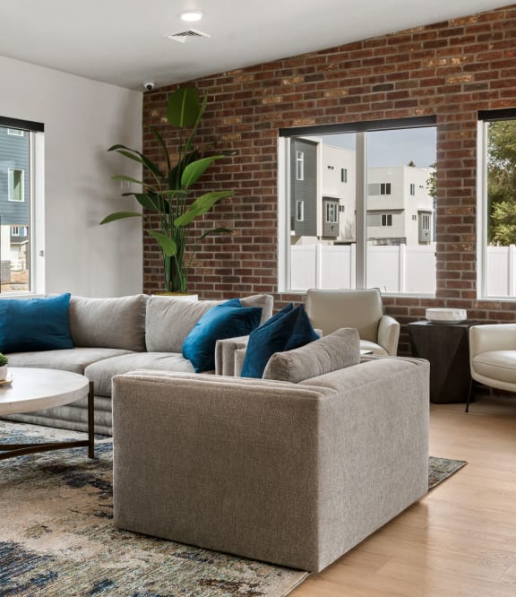 a living room with a brick wall and large windows