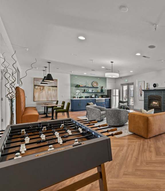 A living room with a foosball table in the foreground.
