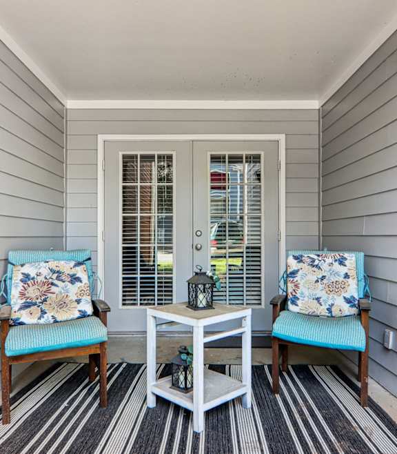 A small porch with a table and two chairs.