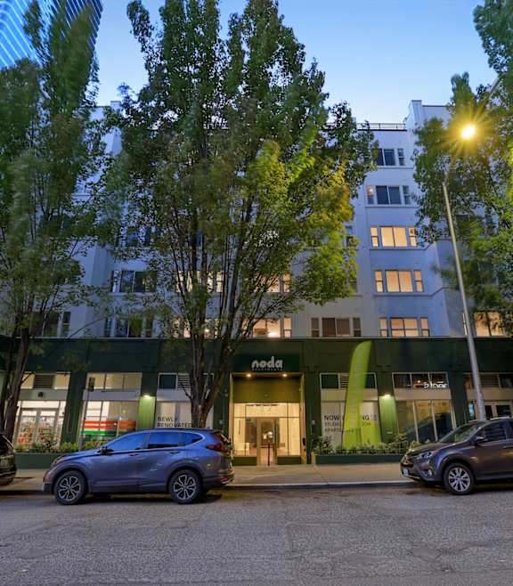 A Nonda store is located in a green building with cars parked in front.