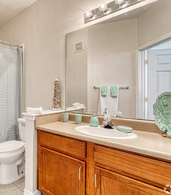 A bathroom with a toilet, sink, and shower.