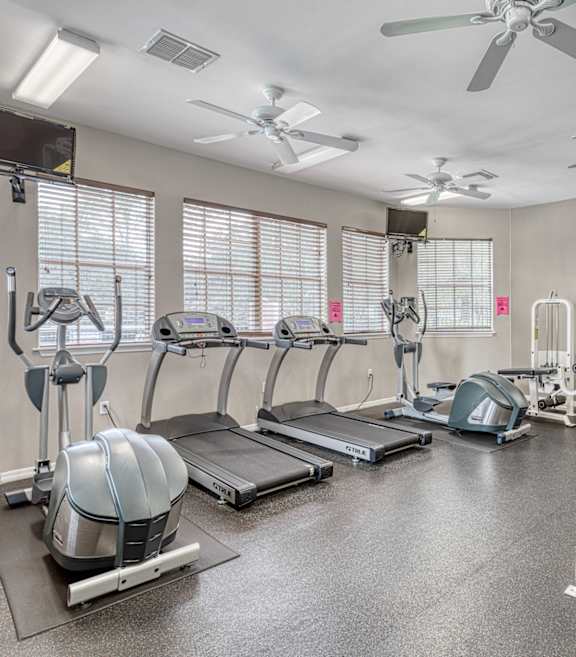 A spacious gym with treadmills, elliptical machines, and weight machines.