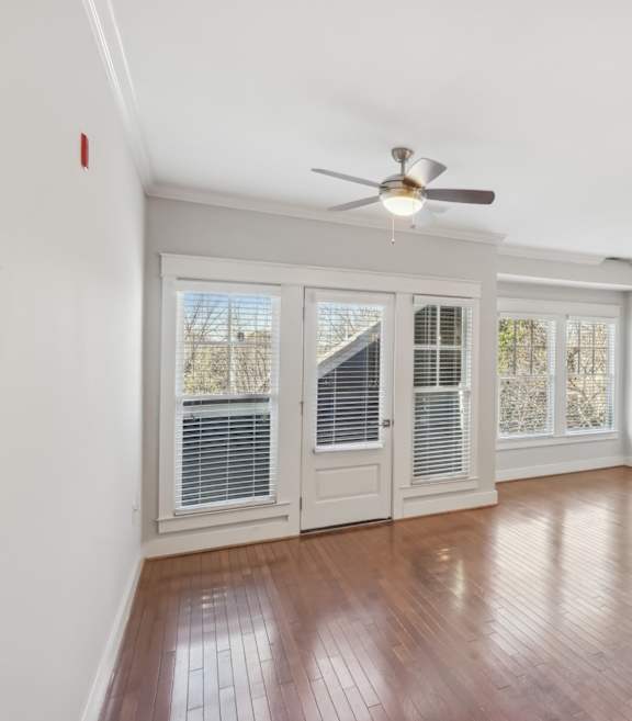 A kitchen with a fan on the ceiling and a sink in the middle.