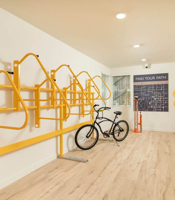 A bike is parked in a room with yellow bike racks.