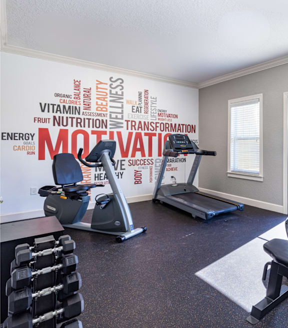 A gym room with a wall of words related to fitness and exercise.