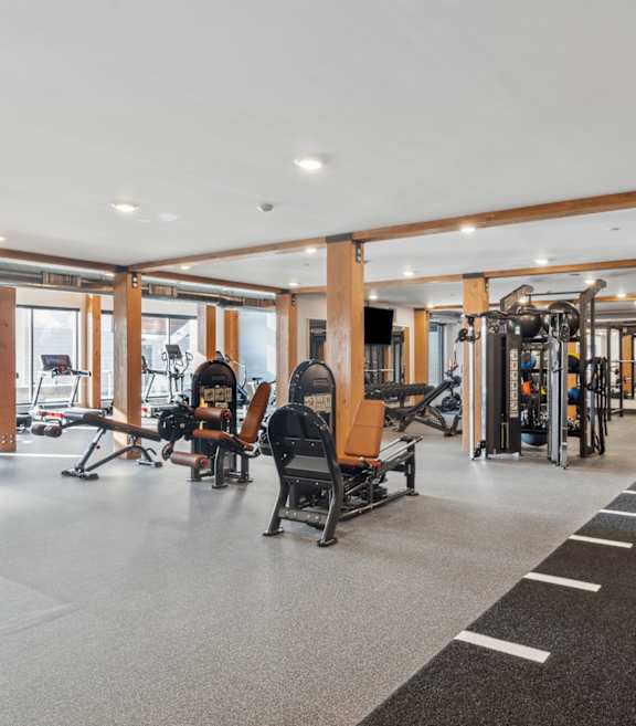 A gym with a variety of equipment including treadmills, weights, and exercise machines.
