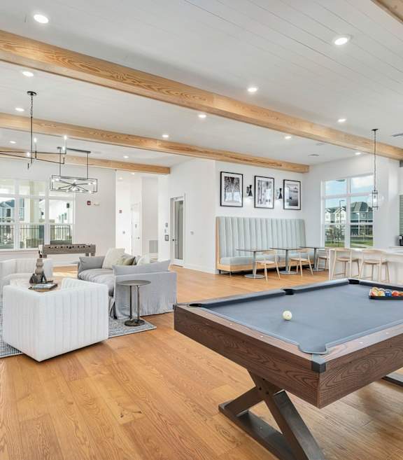 A billiard table is in the middle of a spacious room with a pool table.