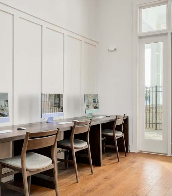 A room with a table and chairs and pictures on the wall.