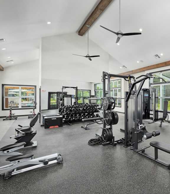 A spacious gym with a variety of equipment including treadmills, weights, and exercise machines at The Percy Apartments, Nashville, TN, 37214