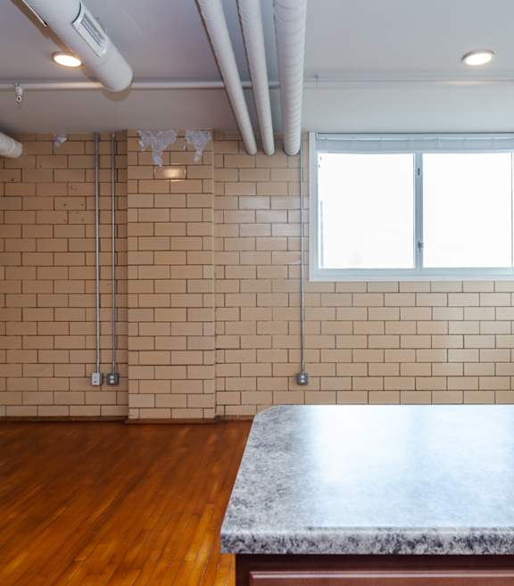 A room with a brick wall and a window.