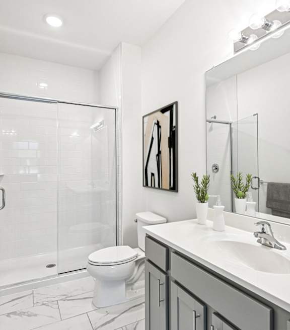 A bathroom with a toilet, sink, and shower.
