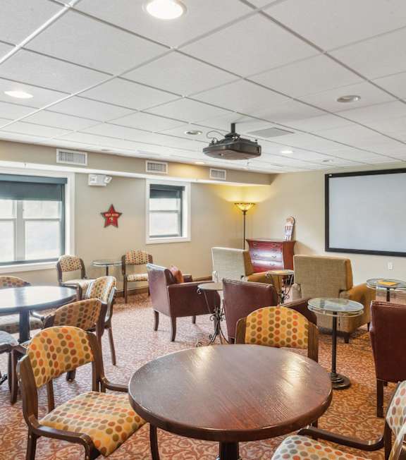 A conference room with a large screen and chairs.