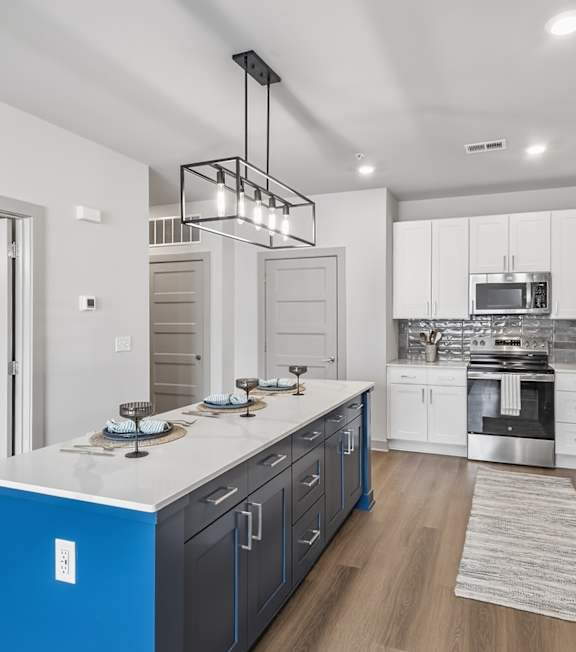 A modern kitchen with a white countertop and stainless steel appliances. at Viridian Apartments LLC Apartments, Bowling Green