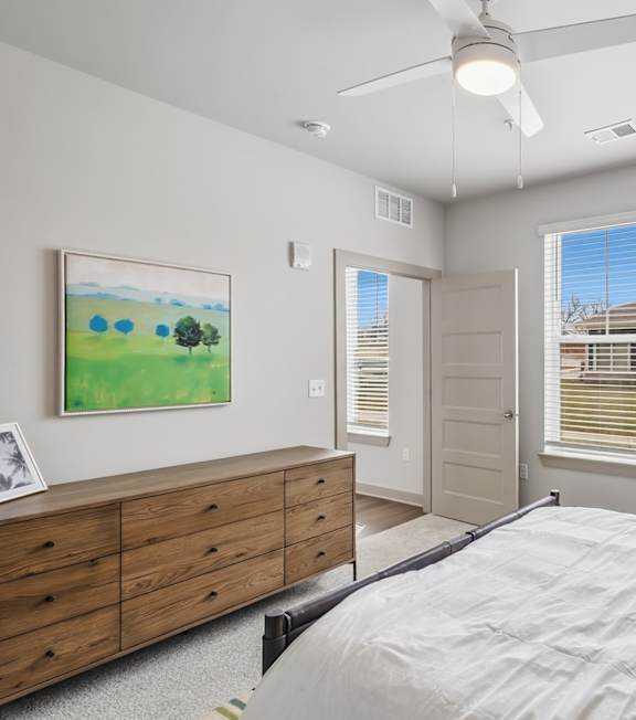 A bedroom with a bed, two lamps, and a painting on the wall. at Viridian Apartments LLC Apartments, Kentucky