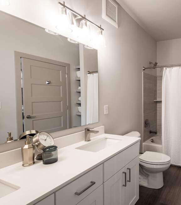 A white bathroom with a toilet, sink, and bathtub. at Viridian Apartments LLC Apartments, Bowling Green