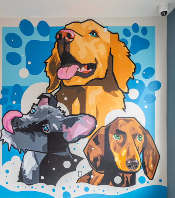A mural of three dogs is painted on a wall. A mural of three dogs is painted on a wall. at Viridian Apartments LLC Apartments, Bowling Green