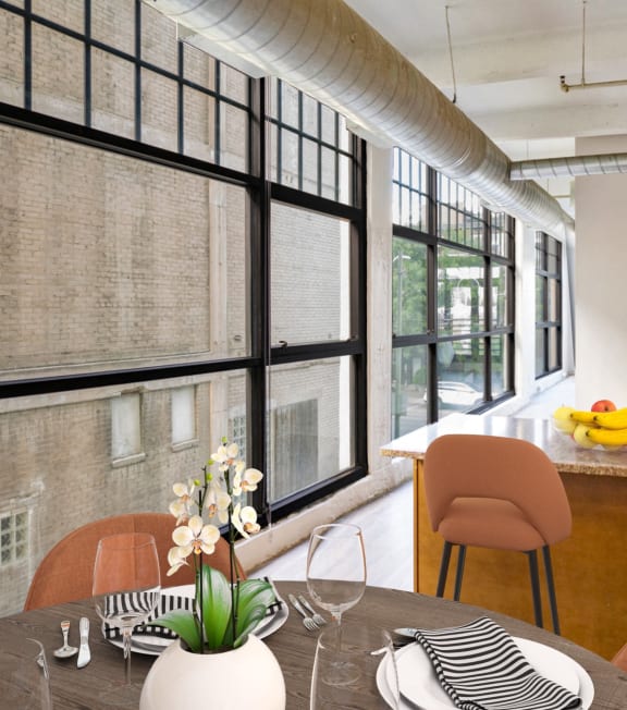 a dining room with a table and chairs and a kitchen with large windows