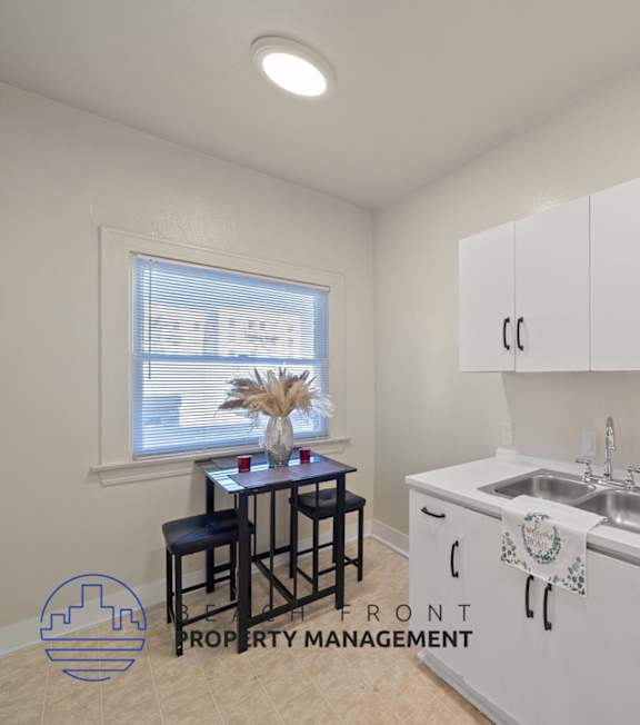 A kitchen with white cabinets and a sink.