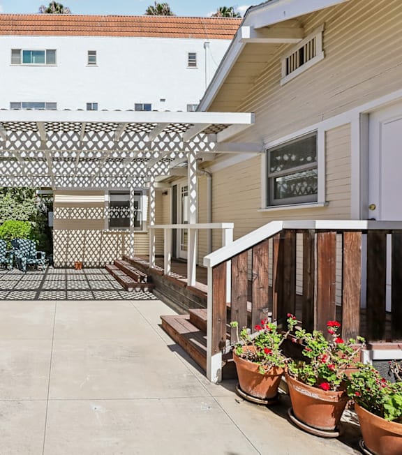 A pool with a hot tub and lounge chairs in front of a building.