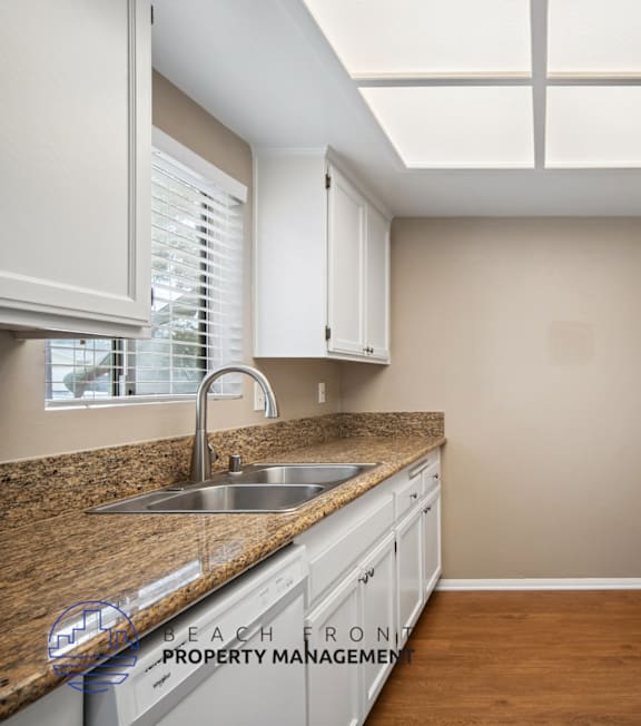 A well-lit, modern kitchen and living room with a dining area.