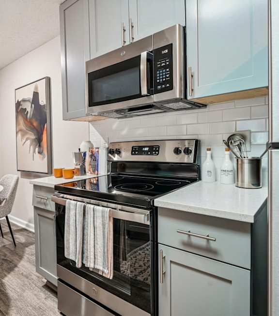 A modern kitchen with a stove top oven and microwave.