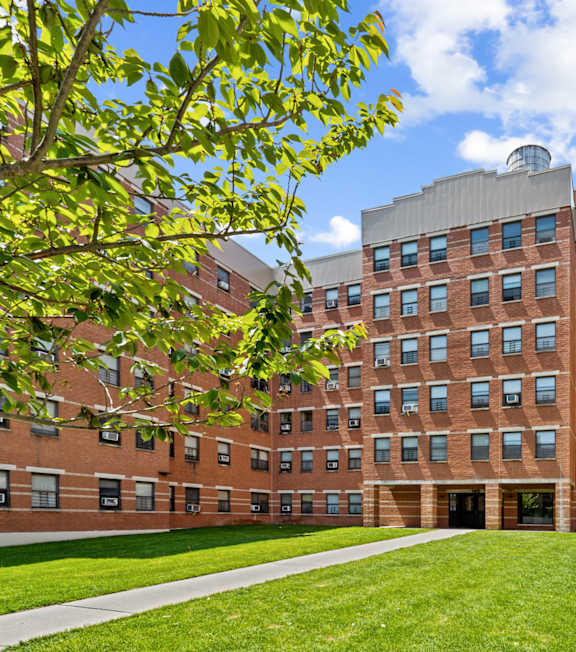 A large red brick building with a green lawn in front.